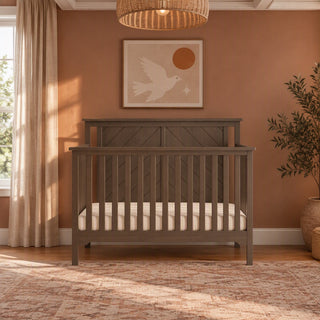 Dapper Gray Child Craft Hampton Flat Top 4-in-1 Convertible Crib with a slatted headboard featuring a diagonal plank design.