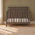 Hampton Flat Top 4-in-1 Convertible Crib in Dapper Gray, made of pine wood with a flat top and diagonal slat detailing on the headboard.