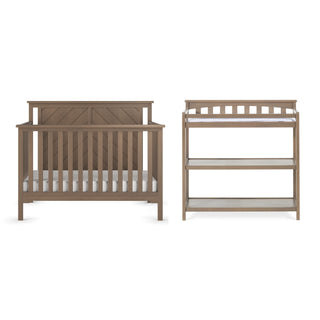 The Child Craft Hampton Flat Top 4-in-1 Convertible Crib in Dusty Heather features vertical slats and a geometric solid headboard, shown next to a matching open-shelf changing table with two shelves, both set against a white background.