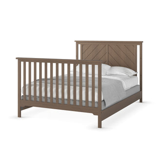 The Child Craft F06401 Full-Size Bed features a matte white finish, vertical slats in a chevron pattern on the headboard and footboard, sturdy pine bed rails, and is styled with white pillows, white sheets, and a gray blanket.