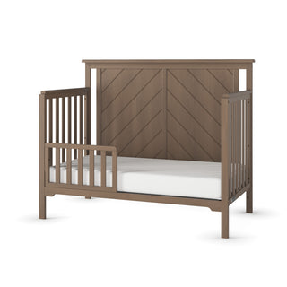 The Child Craft F09501 Toddler Guard Rail in Dusty Heather is shown with a high chevron-patterned headboard, safety rails, and crib conversion options. Includes a white mattress and is displayed against a plain white background.
