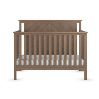 The Child Craft Hampton Flat Top 4-in-1 Convertible Crib in Dusty Heather, crafted from pine wood, features vertical side and front slats, a diagonal high back panel, and a white mattress, displayed on a plain white background.