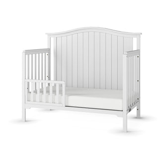 The Child Craft F09501 Toddler Guard Rail in Matte White features sturdy wood construction, an arched headboard, open sides, and a guard rail on one side, displayed against a plain white background.