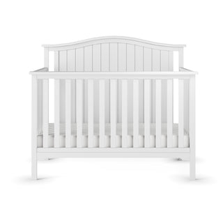 The Child Craft Hampton Arch Top 4-in-1 Convertible Crib in Matte White features a classic design with vertical slats, a curved headboard, adjustable mattress support, and includes a fitted mattress.