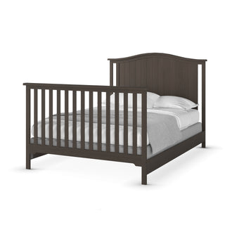 The Child Craft Hampton Arch Top 4-in-1 Convertible Crib in Dapper Grey features a classic slatted design with a neatly made bed, white pillows, and grey bedding, providing timeless style and versatility.