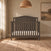 Dapper Grey Hampton Arch Top 4-in-1 Convertible Crib made of pine wood with an arched headboard and a white mattress.