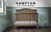 The Child Craft Hampton Arch Top 4-in-1 Convertible Crib in Dusty Heather features unique shiplap paneling, a stylish arch top, three finishes, and converts to four bed types—perfect for a green-paneled nursery.