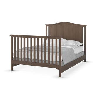 The Child Craft Hampton Arch Top 4-in-1 Convertible Crib in Dusty Heather features vertical slats on the headboard and footboard, shown with white bedding and a gray blanket, and photographed against a white background.