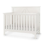 The Child Craft Woodland 4-in-1 Convertible Crib in Brushed Cotton features slatted sides, a solid panel headboard, and a modern farmhouse design. Shown empty against a plain white background.