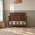 Child Craft Woodland 4-in-1 Convertible Crib in Brushed Truffle with a farmhouse-style headboard featuring a horizontal cross-brace detail and adjustable mattress support.