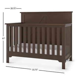 The Child Craft Woodland 4-in-1 Convertible Crib in Brushed Truffle features dark brown pine wood, vertical slats, a solid, decoratively trimmed back panel, adjustable mattress support, and measures 47"H x 55.75"W x 30.75"D.