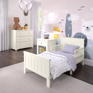 A cozy children’s bedroom with white furniture, including a toddler bed, nightstand, and the Child Craft Harmony 3-Drawer Dresser with Changing Table Topper in Brushed Cotton. Pastel animal murals decorate the walls, and daylight shines through sheer curtains.