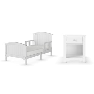 The Child Craft Hampton Toddler Bed in Matte White features a panel headboard, guard rails, and is low to the ground. Includes a matching nightstand with one drawer and an open shelf for storage. Both pieces offer a simple, classic look.