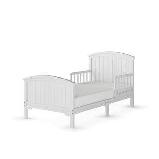 The Child Craft Hampton Toddler Bed in Matte White features a panel headboard, footboard, side guard rails for safety, and slatted detailing. Designed for a standard crib mattress. Shown on a plain white background.