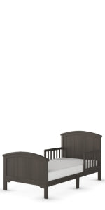 The Child Craft Hampton Toddler Bed in Dapper Gray features slatted sides, a high headboard, low footboard, and guard rails for safety. A white crib mattress sits on its sturdy frame. Set against a plain white background.
