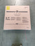 A large brown cardboard box labeled Child Craft sits on a gray floor. The box may contain a Hampton Toddler Bed, Dapper Gray, and features safety warnings, handling instructions, plus a bright yellow label in the upper left corner.