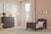 A cozy toddler bedroom with a Child Craft Hampton Toddler Bed in Dapper Gray featuring guard rails, a matching dresser, pink polka dot accent wall, animal art, light curtains, a rocking horse, and soft natural window light.