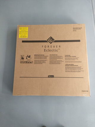 A large brown cardboard box labeled Child Craft lies on a gray surface. The box has black printed text, symbols, a yellow warning label in the top left corner, and contains the Hampton Toddler Bed in Dusty Heather.