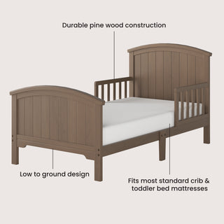 The Child Craft Hampton Toddler Bed in Dusty Heather features an arched headboard, low profile, and side rails. Made from pine wood, it fits crib and toddler mattresses for a safe and stylish transition to a big kid bed.