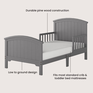 The Child Craft Hampton Toddler Bed in Cool Gray features a durable pine wood frame, low-to-floor design, and sturdy guard rails for safety. Fits standard crib and toddler bed mattresses (mattress shown not included).