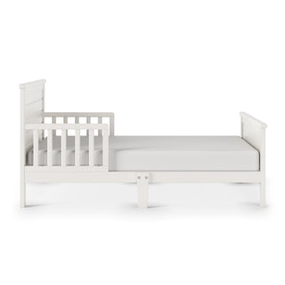The Child Craft Woodland Toddler Bed in brushed cotton features sturdy bed rails, a headboard, a footboard, and includes a plain white mattress.