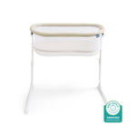 The HALO BassiNest® Lite Portable Bassinet, in white and beige with mesh sides and white metal legs, is shown on a white background with a Baby Safety Alliance Verified badge in the bottom right corner.