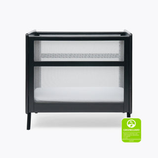 The HALO Mini Breathable Mesh Crib in black with a white mattress is shown against a plain light background. A green GREENGUARD Gold certification badge is visible in the lower right corner.