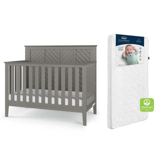 The Child Craft Atwood 2-Piece Crib and DreamWeave Set in Lunar Grey features a chevron headboard crib next to an upright HALO DreamWeave breathable crib mattress with baby image and GREENGUARD label on the package.