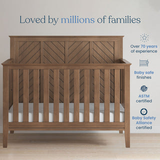 A Child Craft Atwood 2-Piece Crib and DreamWeave Set, Cocoa Bean, stands in a room with text above: “Loved by millions of families.” Icons on the right highlight safety, certifications, 70 years’ experience, and HALO DreamWeave compatibility.