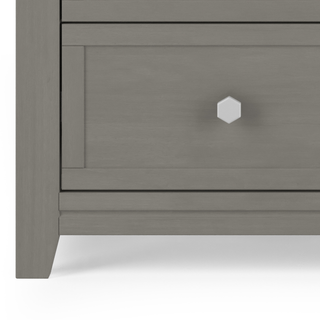 Close-up of a gray wooden drawer with a hexagonal silver knob, part of the Child Craft Atwood 3-Drawer Dresser in Lunar Gray. Its clean lines and modern style make it ideal for nurseries or pairing with a baby changing table topper.