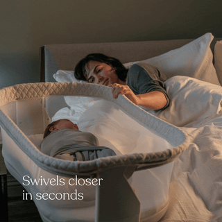 A woman in bed reaches for her baby sleeping in the HALO BassiNest® Swivel Sleeper 4.0 Air with Dreamweave Breathable Pad beside her. Text reads, “Swivels closer in seconds.”.