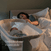 A woman in bed reaches for her baby sleeping in the HALO BassiNest® Swivel Sleeper 4.0 Air with Dreamweave Breathable Pad beside her. Text reads, “Swivels closer in seconds.”.
