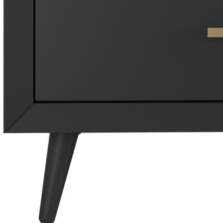 Close-up of the Child Craft Cranbrook 4-Drawer Chest - Ebony highlights its gold rectangular handle and tapered legs, offering a modern, minimalist look influenced by classic Mid-Century Modern dresser design.