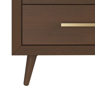 A close-up of the Child Craft Cranbrook Double Dresser in Toasted Chestnut highlights its elegant mid-century modern design with an angled leg and brass drawer handle—an ideal nursery furniture piece.