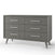 The Child Craft Cranbrook Double Dresser in Lunar Gray features six drawers, sleek metal handles, and angled legs, making it a stylish nursery furniture piece. Shown against a plain white background.