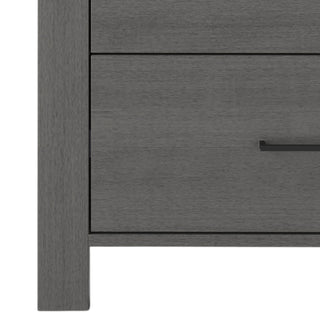 Close-up of the left side of the Child Craft Denman 4 Drawer Chest in Midnight Gray, featuring a modern design with straight lines and black handles—ideal nursery furniture.