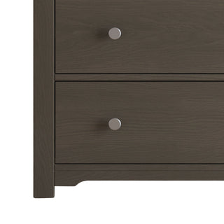 A close-up of the bottom two drawers of the Child Craft Harmony 3-Drawer Dresser with Changing Table Topper in Dapper Gray, each featuring round silver knobs. Only the left side of this nursery furniture is shown.