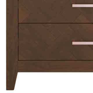 Close-up of the left side of the Child Craft Kieran 5-Drawer Chest in Toasted Chestnut with two visible drawers, each featuring a sleek rectangular metallic handle—an elegant addition to any nursery.