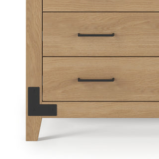 Close-up of the Child Craft Lucas Dresser in Nutmeg shows two drawers with black metal handles, shiplap detailing, a black corner bracket, and stands on a white surface.