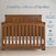 A Child Craft Redmond Full Panel 2-Piece Crib and DreamWeave Set in Coach Cherry stands against a light wall. Boasting baby-safe finishes, this convertible crib is ASTM and Baby Safety Alliance certified, trusted by millions of families.