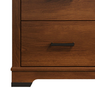 A close-up of the bottom corner of the Child Craft Redmond 3 Drawer Dresser in Coach Cherry, featuring two drawers with black metal handles and a dark base trim—ideal for nursery storage.
