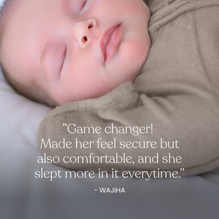 A close-up of a sleeping baby in the soft, beige HALO SwaddleStretch™ Newborn Swaddle TOG 0.5. Text overlay: “Game changer! Made her feel secure but also comfortable, and she slept more in it everytime.” – WAJIHA.