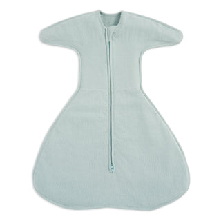 The HALO SwaddleStretch™ Newborn Swaddle TOG 0.5 features a center zipper, wide sleeves, and a roomy bottom. Made from soft fabric, this hip-healthy sleep sack ensures cozy comfort and warmth for infants.