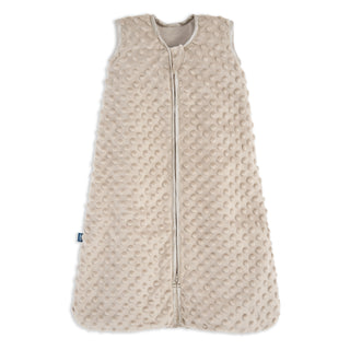 The HALO Wearable Blanket Plushy Dot Velboa TOG 1.5 is a beige, sleeveless sleep sack made of soft fabric with raised dots and a full-length front zipper for safe and comfortable sleep.