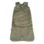 The HALO Swaddle Plushy Dot Velboa TOG 3.0 is an olive green sleep sack with soft, textured fabric, a raised dot pattern, front zipper, and adjustable swaddle wings for comfort.