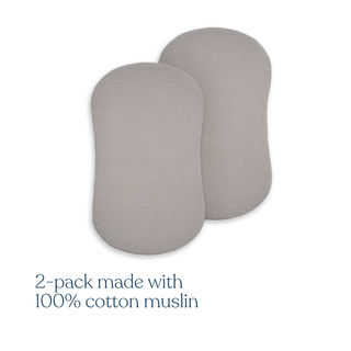 Two light gray, oval BassiNest® Fitted Sheets by HALO are shown overlapping. Text below: 2-pack made with 100% organic cotton muslin—breathable and ideal for use as crib sheets or HALO BassiNest fitted sheets.