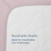 Close-up of the HALO Fitted Crib Sheets 100% Organic Cotton Muslin 2 Pack in mauve on a white crib mattress. Text on the mattress reads: “Breathable Muslin. Ideal for breathable crib mattresses.”.