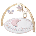 The aden + anais baby activity gym includes a wooden arch with butterfly, bird, and bunny toys. It features a pastel floral padded mat and crescent pillow, all made from eco-friendly materials to aid your babys developmental skills.