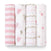 Four aden + anais boutique 100% cotton muslin swaddle blankets are displayed upright with breathable patterns: pink/white stripes, hearts/dots, wavy lines, and scattered dots in pink, grey, and beige hues. These swaddles ensure absorbency and comfort on a clean white background.