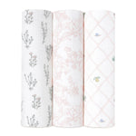 Three vertically displayed rolls of aden + anais boutique silky soft swaddle blanket 3 pack include a botanical design with small plants, delicate pink floral illustrations, and a lattice pattern with flowers and leaves.